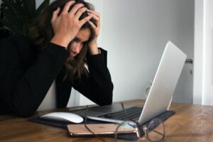 stressed woman working on a laptop