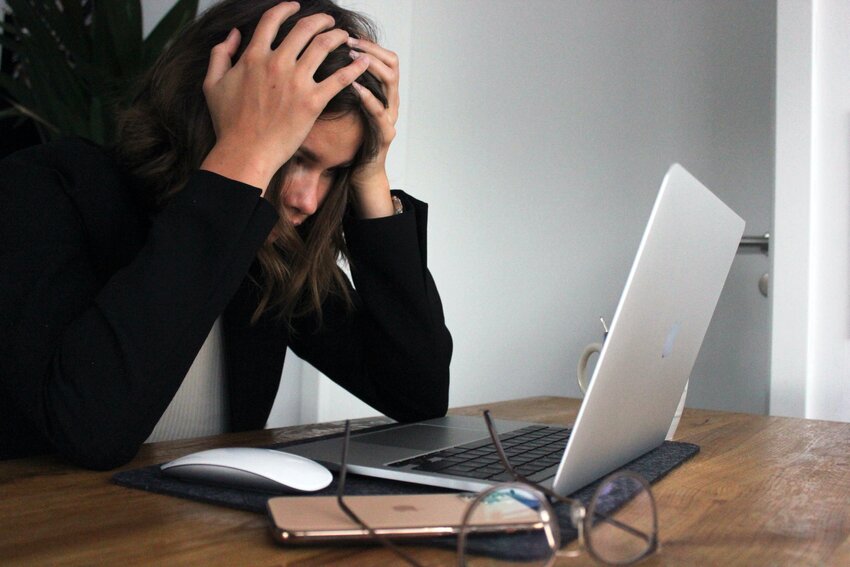 stressed woman working on a laptop